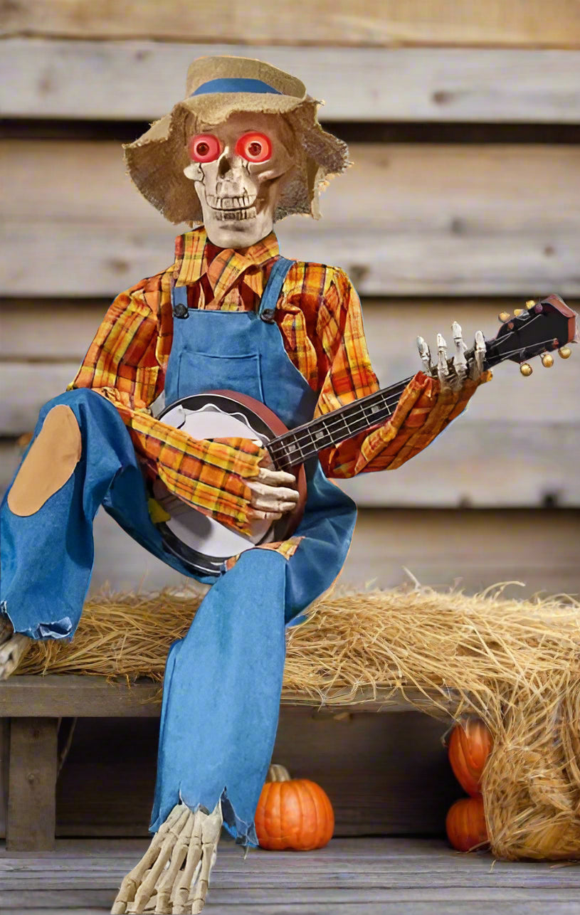 skeleton banjo player Halloween decoration wearing plaid shirt and overalls with glowing red eyes on hay bale 2025